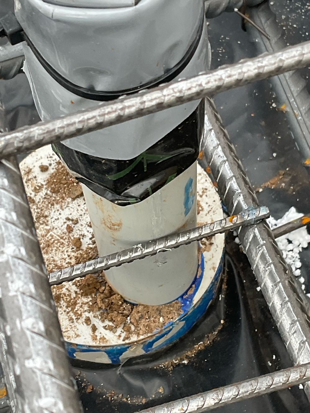 Slab mesh resting against service pipes where 25 mm of clearance is needed, found during a slab pre-pour inspection in Manor Lakes