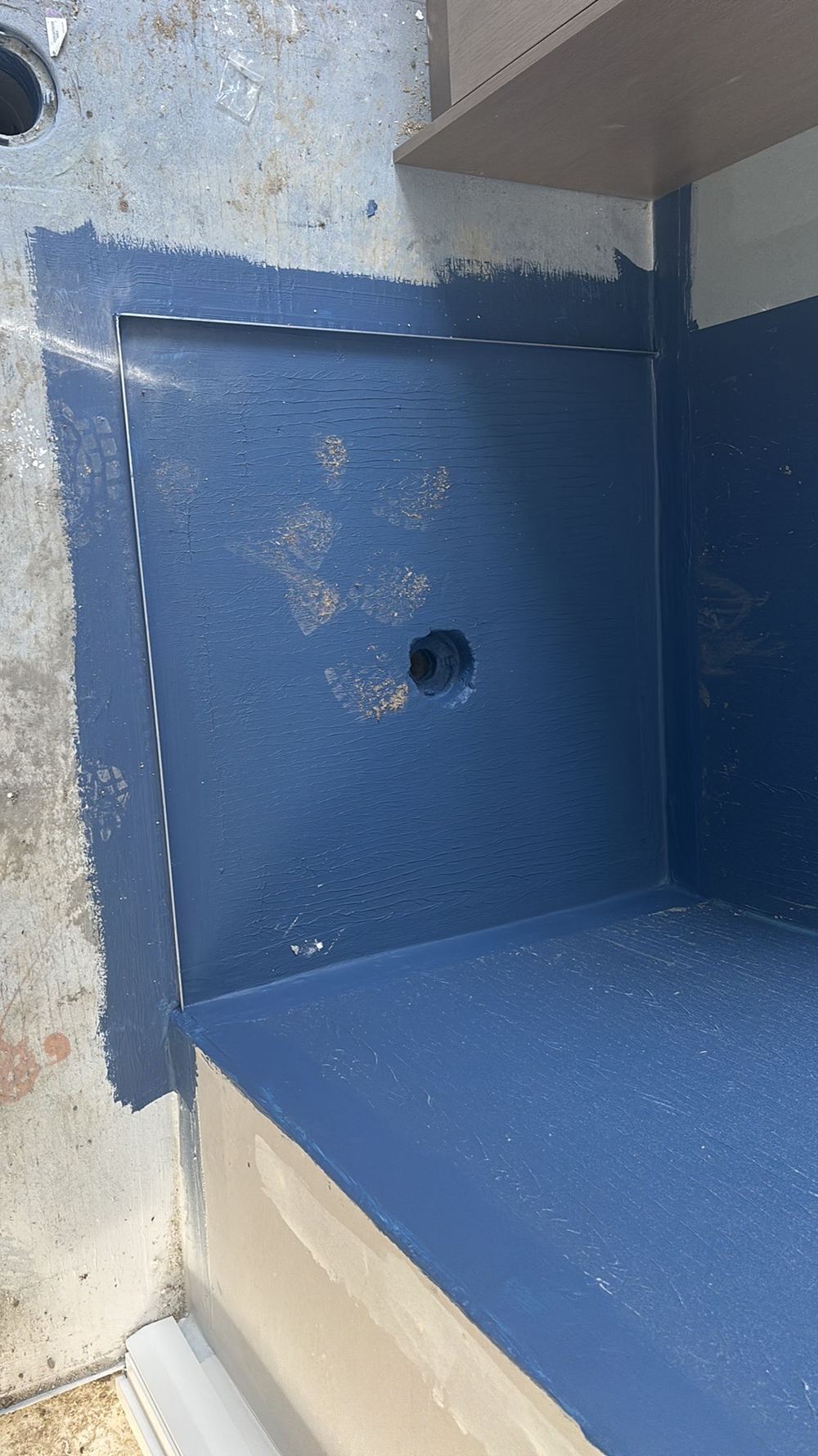 Membrane left exposed to boots and other trades before tiling, found during a waterproofing stage inspection in Manor Lakes